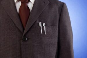 Gros plan sur une veste de costume sombre, évoquant l'idée d'un dispositif d'espionnage discret comme une bouton caméra.