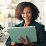Woman, tablet and happy at office with project, thinking or review with article at media agency. Person, journalist and writer with research, editing process and tech with app for story development